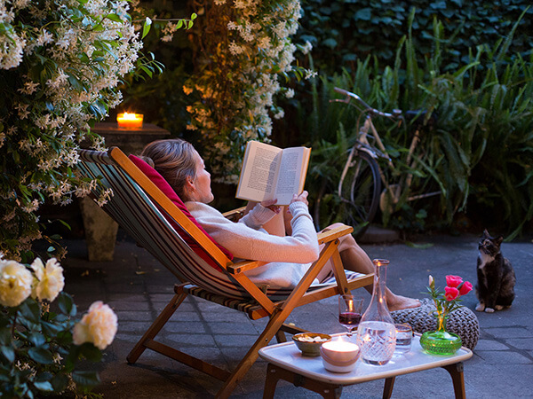 Woman relaxing spa side in chair reading a book