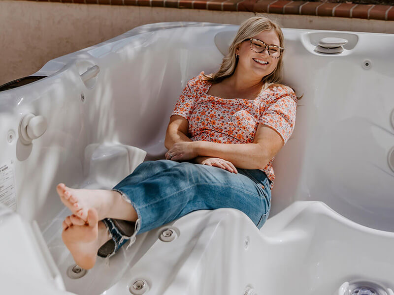 Caldera Spas Brand Manager sitting in the UltraMassage® Lounge.